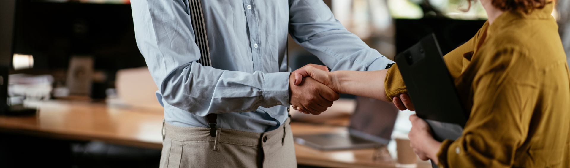 Colleagues in office Businesswoman and businessman handshake