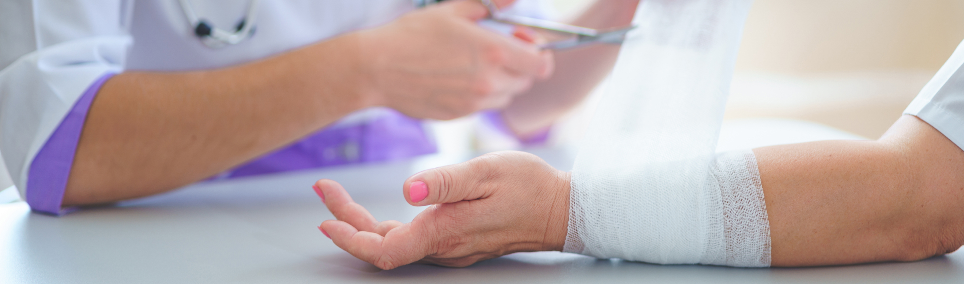 Doctor is bandaging wrist of patient in clinic