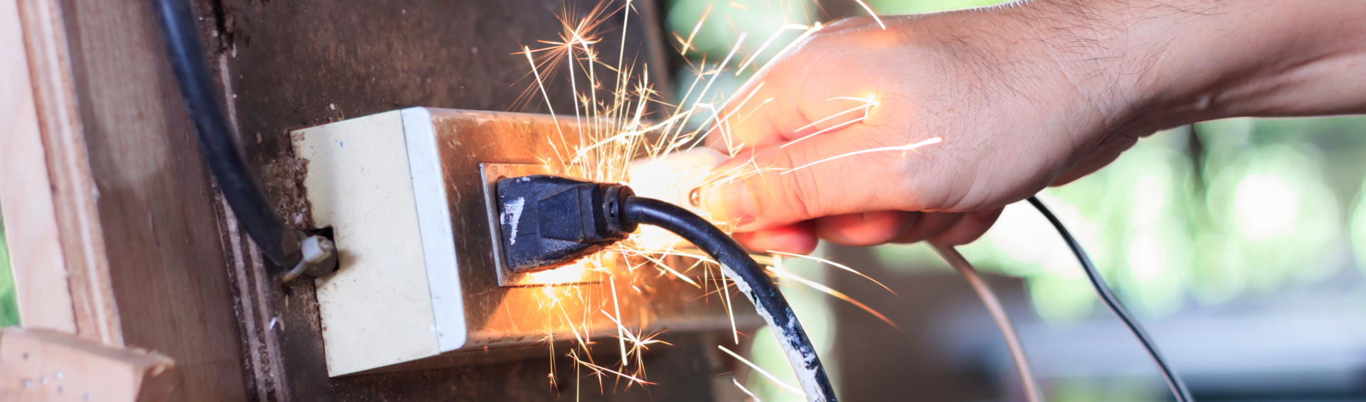 A short circuit sparking from a power chord in an outlet injuring a person - Product Liability Attorneys concept image