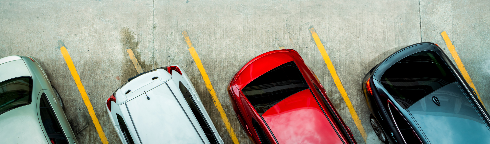 Top view of car parked at concrete car parking lot with yellow line of traffic sign on the street